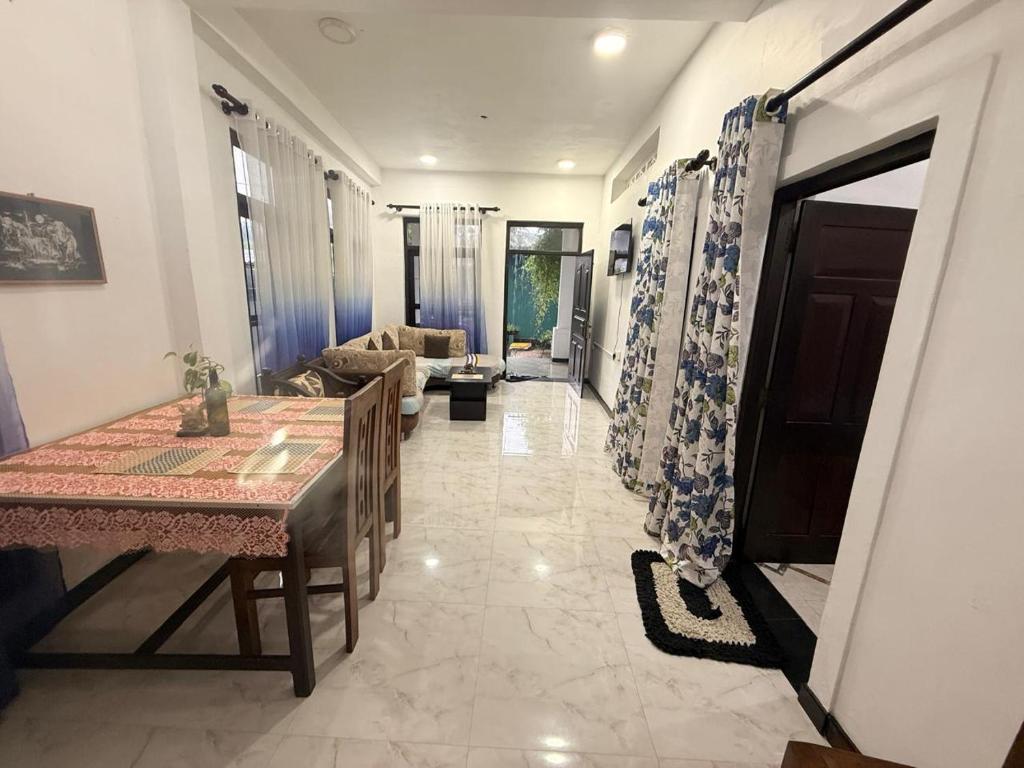 a dining room with a table and a living room at Liora Villa in Negombo