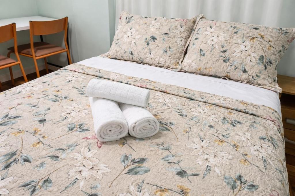a bedroom with a bed with towels on it at Apto Central com Wi-Fi Rápido e Workspace in Niterói