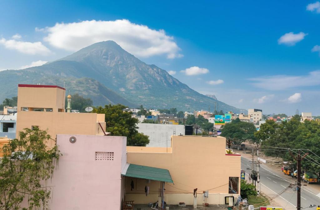a mountain in the background of a city with a building at gururesidency in Tiruvannāmalai