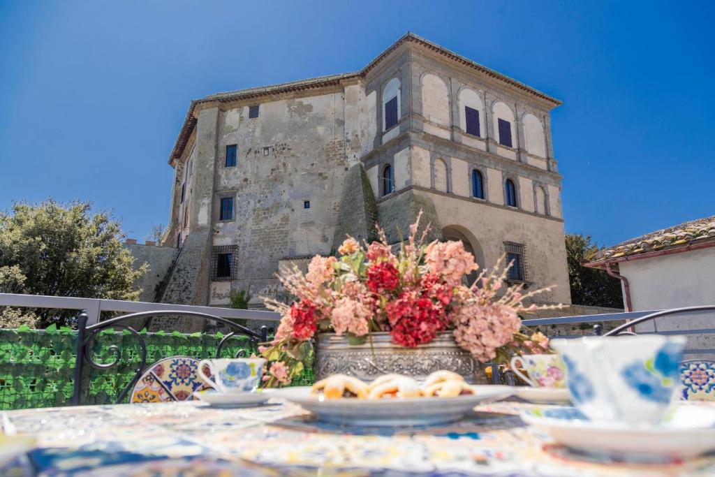 a table with a vase of flowers on top at La Terrazza sul Lago in Capodimonte