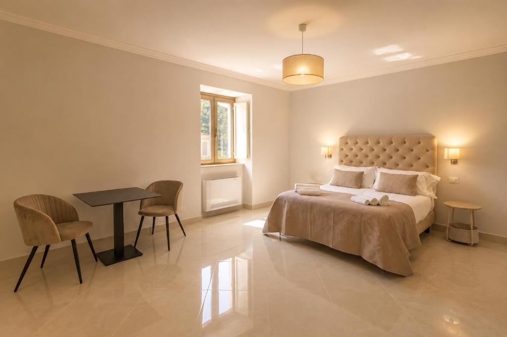 a bedroom with a bed and a table and chairs at Fenisien Boutique Rooms in Contursi