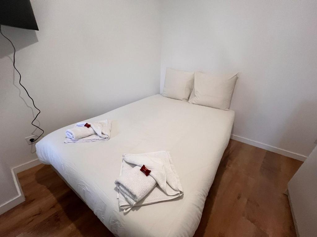 a small bedroom with a white bed with towels on it at Studio Opale in Lille