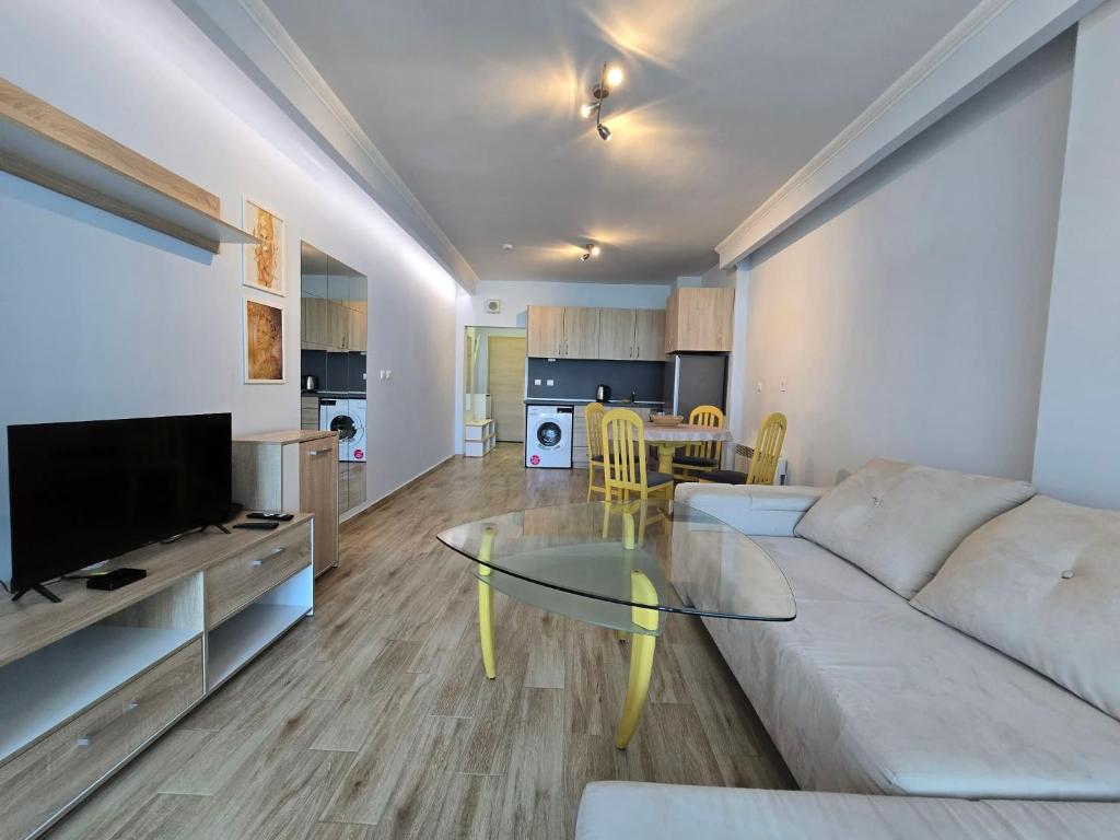 a living room with a couch and a glass table at GOLD Residence in Sofia