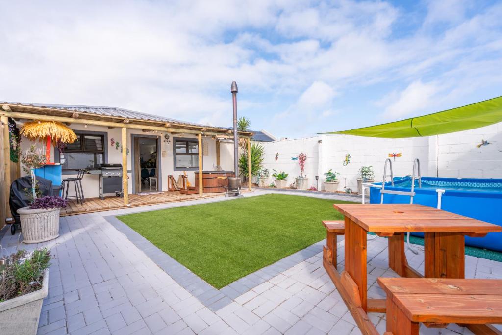 an outdoor patio with a table and a lawn at Where Time Stops in Langebaan