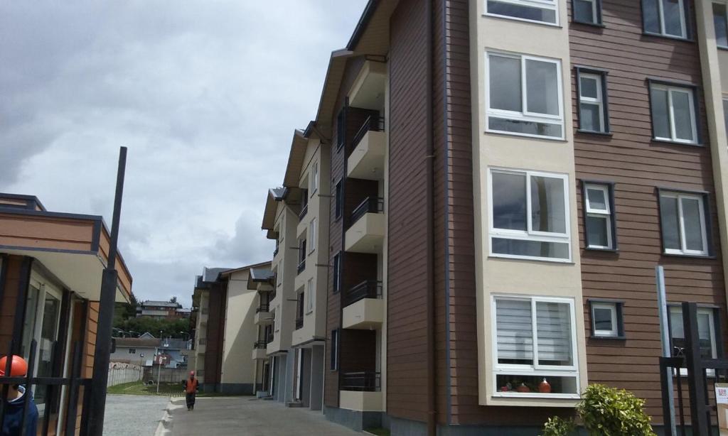 a row of apartment buildings on a street at Plaza Brintrup in Puerto Varas
