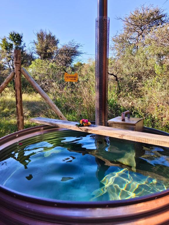 a hot tub with water and flowers in it at Romantic Hot Tub Retreat - Ndlovu 33 Tiny Home, Big 5 reserve in Klipdrift