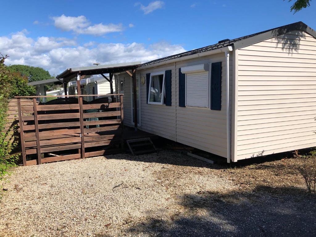 a white trailer parked next to a wooden fence at Mobilhome avec piscine in Ruoms
