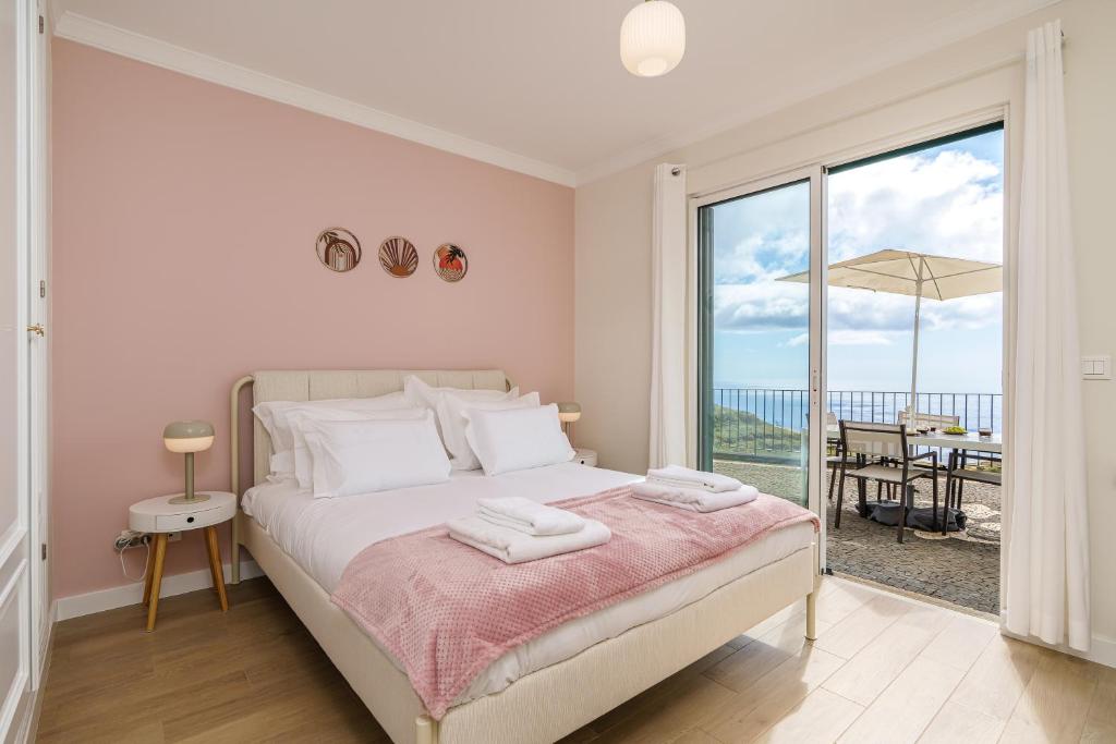 a bedroom with a bed with a view of the ocean at Villa Pargo Green by Madeira Dream Stays in Ponta do Pargo