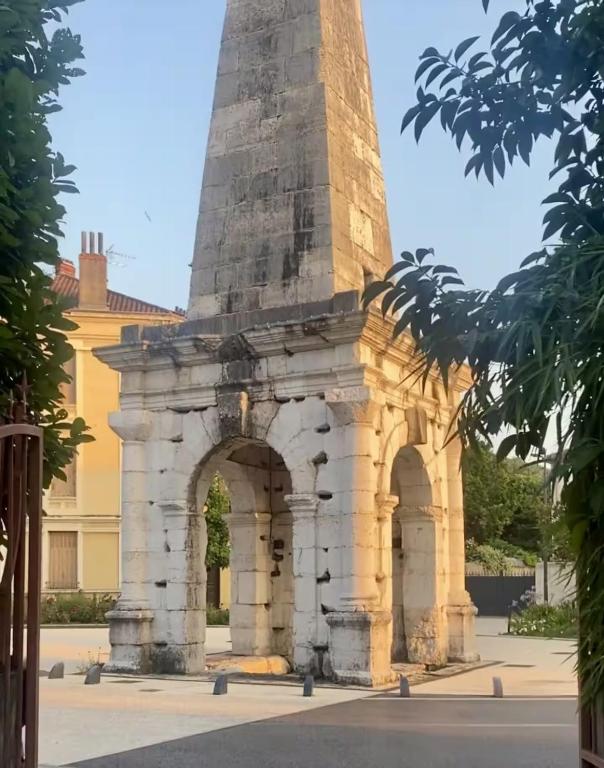 a monument in front of a building with a tower at Appartement avec jacuzzi et vue sur Pyramide in Vienne