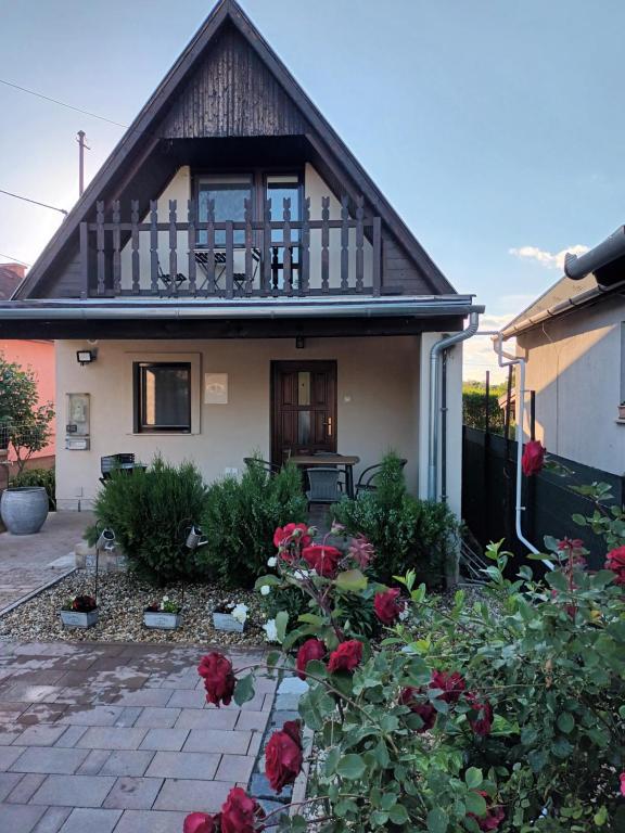 a house with a balcony and flowers in front of it at Tücsi lak in Szigetszentmárton