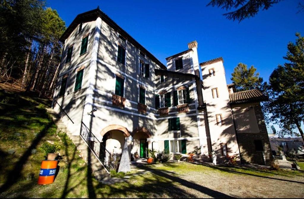 a large white building with an archway in a yard at Agriturismo Relais Kloe in Castel Boglione