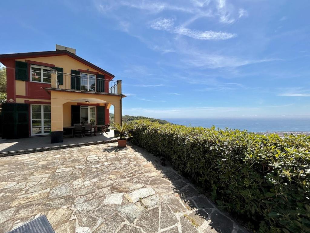 a house on a hill with the ocean in the background at COGO, Premium Private Villa Vista Mare in Cogorno