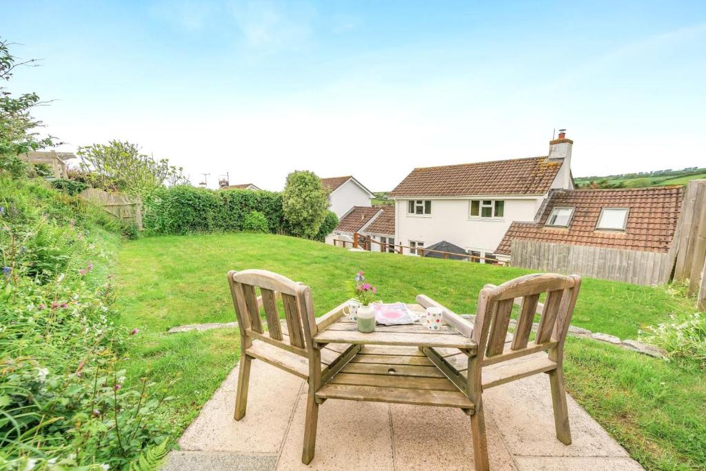 a wooden table with two chairs in a yard at 3 Bed in Georgeham oc-halcy in Georgeham