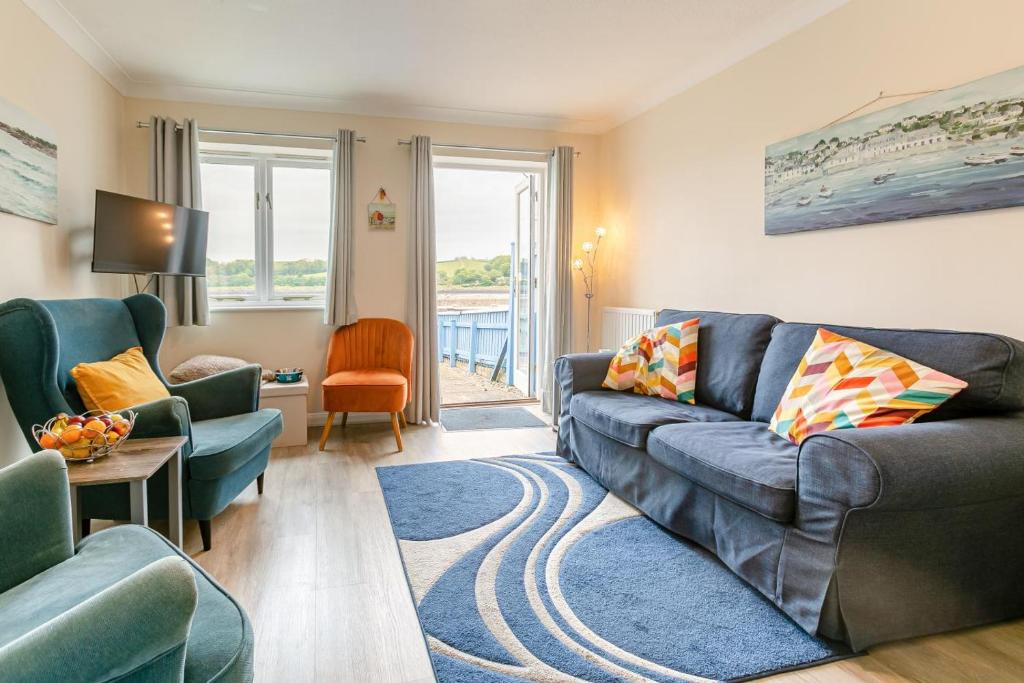 a living room with a blue couch and chairs at 2 Bed in Bideford oc-rives in Bideford