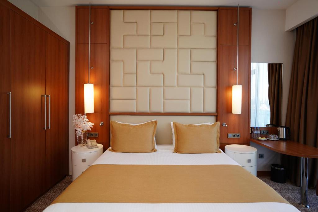 a bedroom with a large bed and a desk at Grand Bellagio Hotel Batumi in Batumi