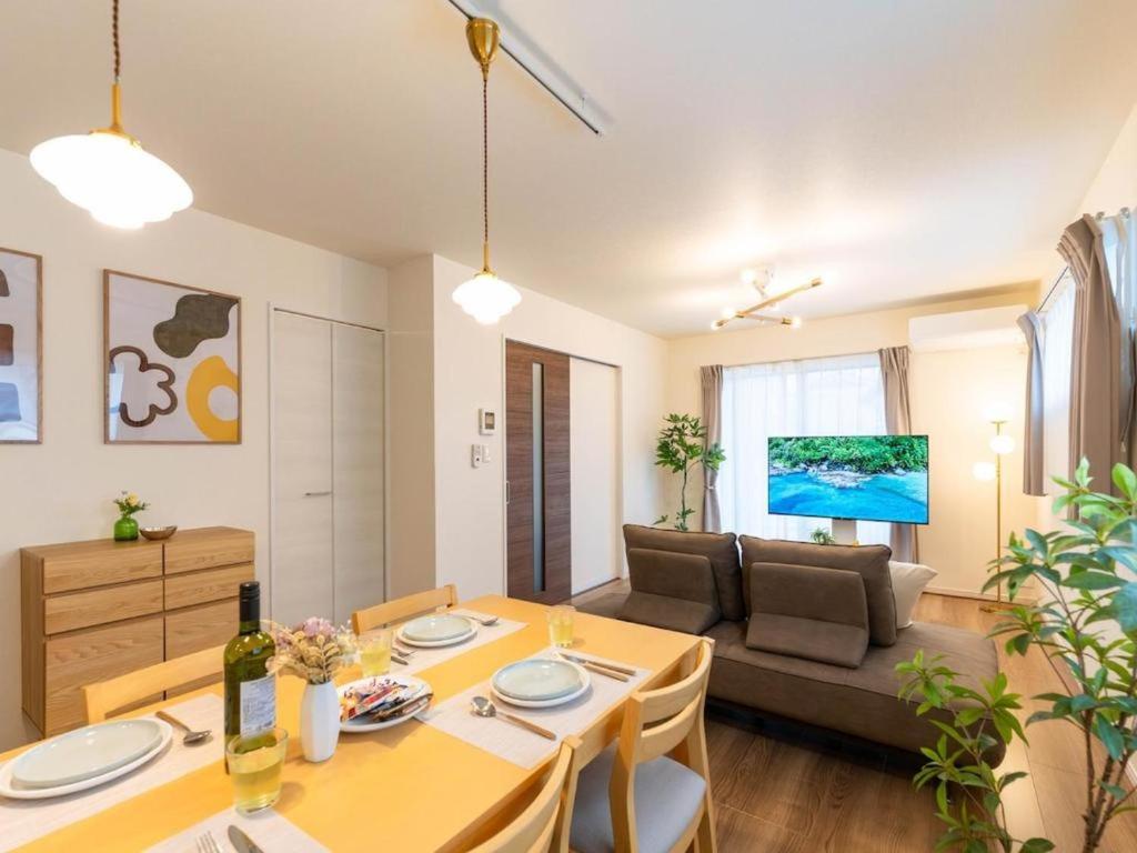 a living room with a table and a couch at HIRO HOUSE Marugame - 丸亀駅徒歩5分 in Marugame