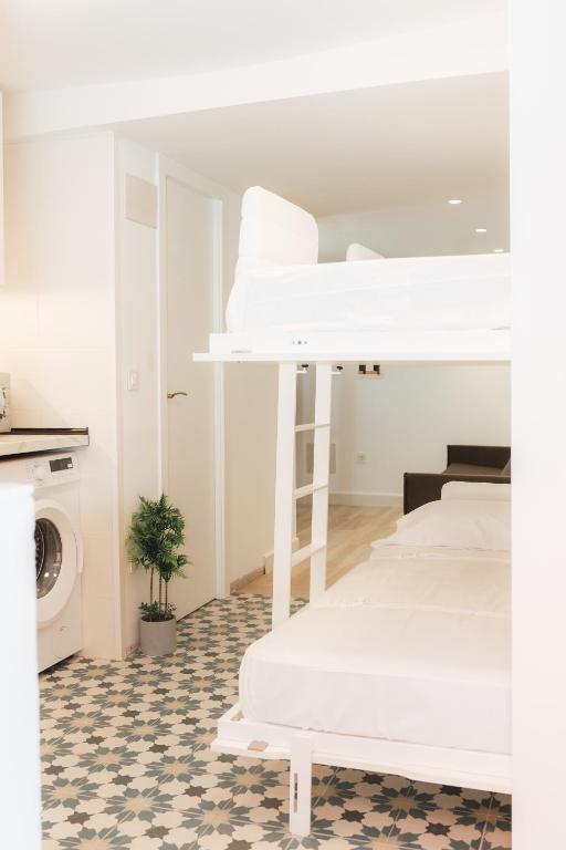 a room with white beds and a washing machine at Trepat Harbor's Light in Villajoyosa