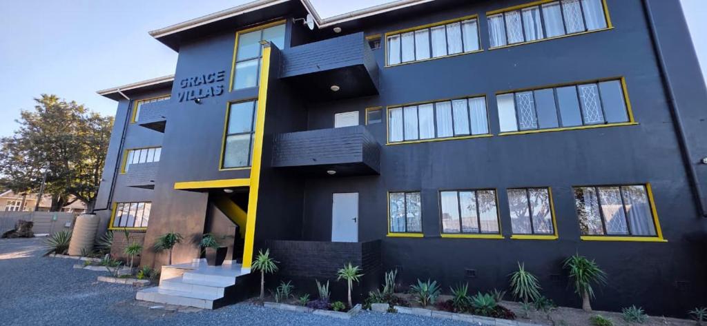 a large blue building with yellow accents at Grace Villas 35 in East London