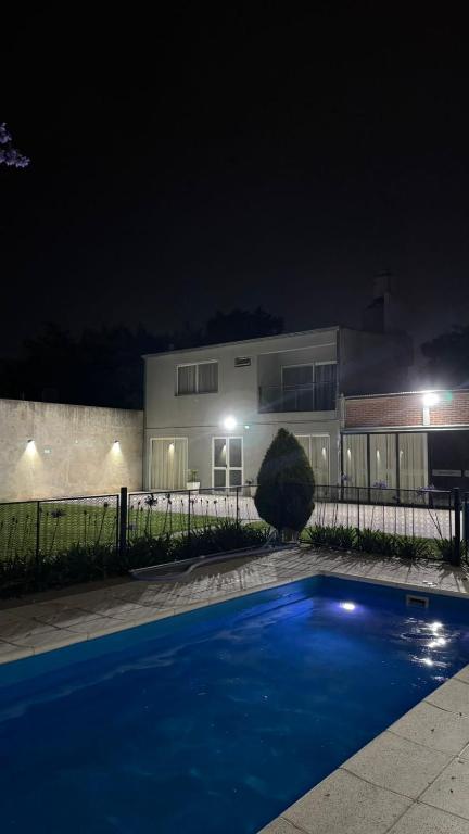 a house with a swimming pool at night at Hospedaje Buena Vibra in San Nicolás de los Arroyos