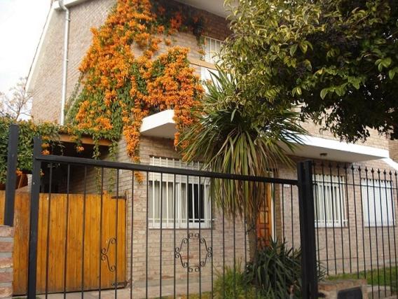 una casa con flores naranjas a un lado. en Casa Villa Carlos Paz en Villa Carlos Paz