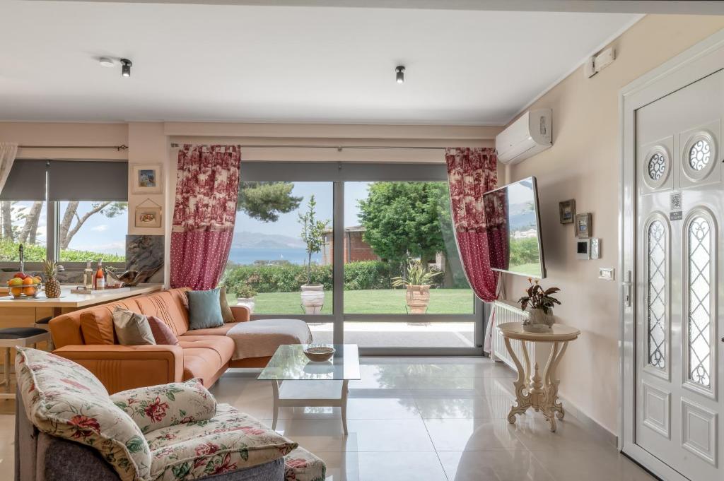 a living room with a couch and a table at Celeste Sea View Home with Jacuzzi and BBQ in Psalidi