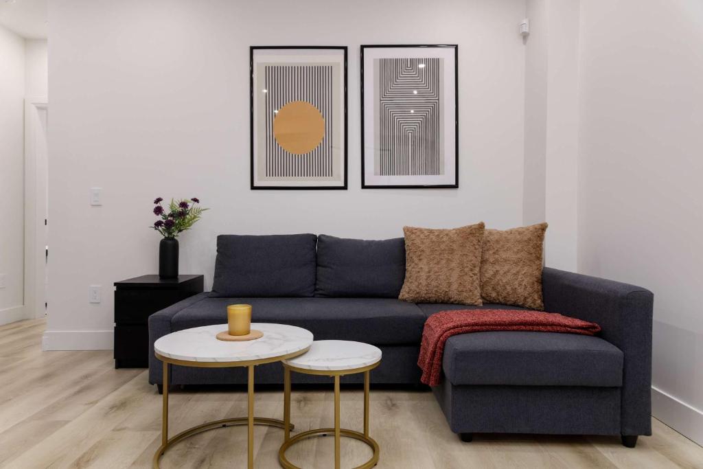 a living room with a blue couch and two tables at Newly Built Suite-West Coquitlam in Coquitlam
