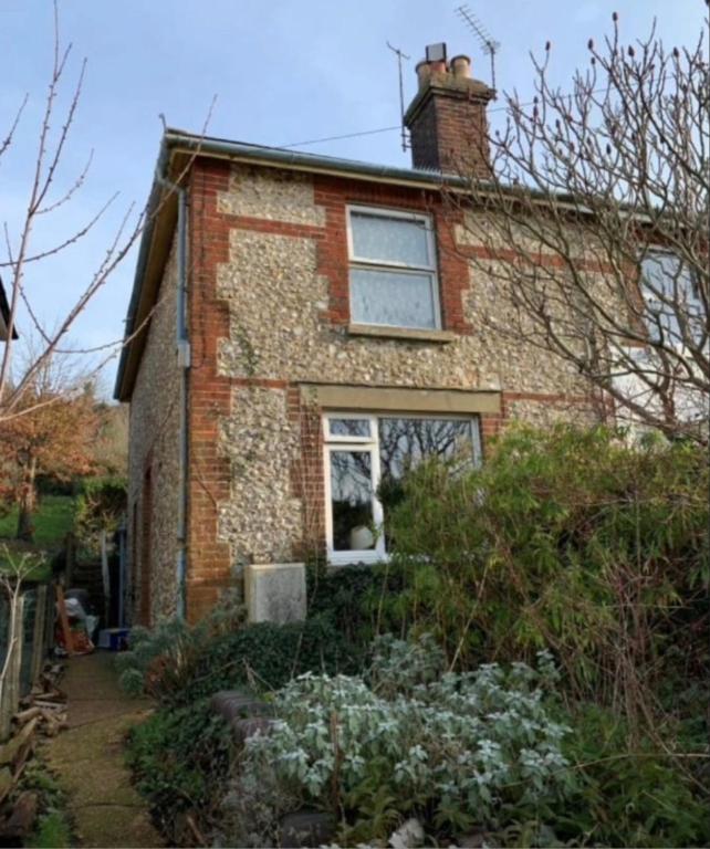 a brick house with a window and some bushes at Sage Cottage Ventnor in Ventnor