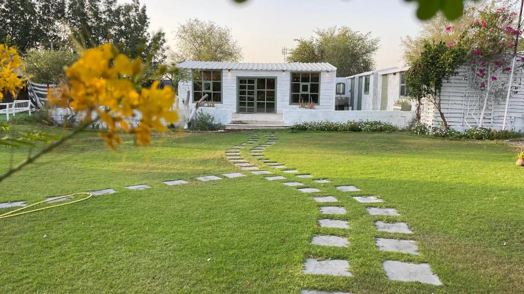 a garden with a cobblestone path in front of a house at Oasis Rest ae in Madīnat an Nahḑah