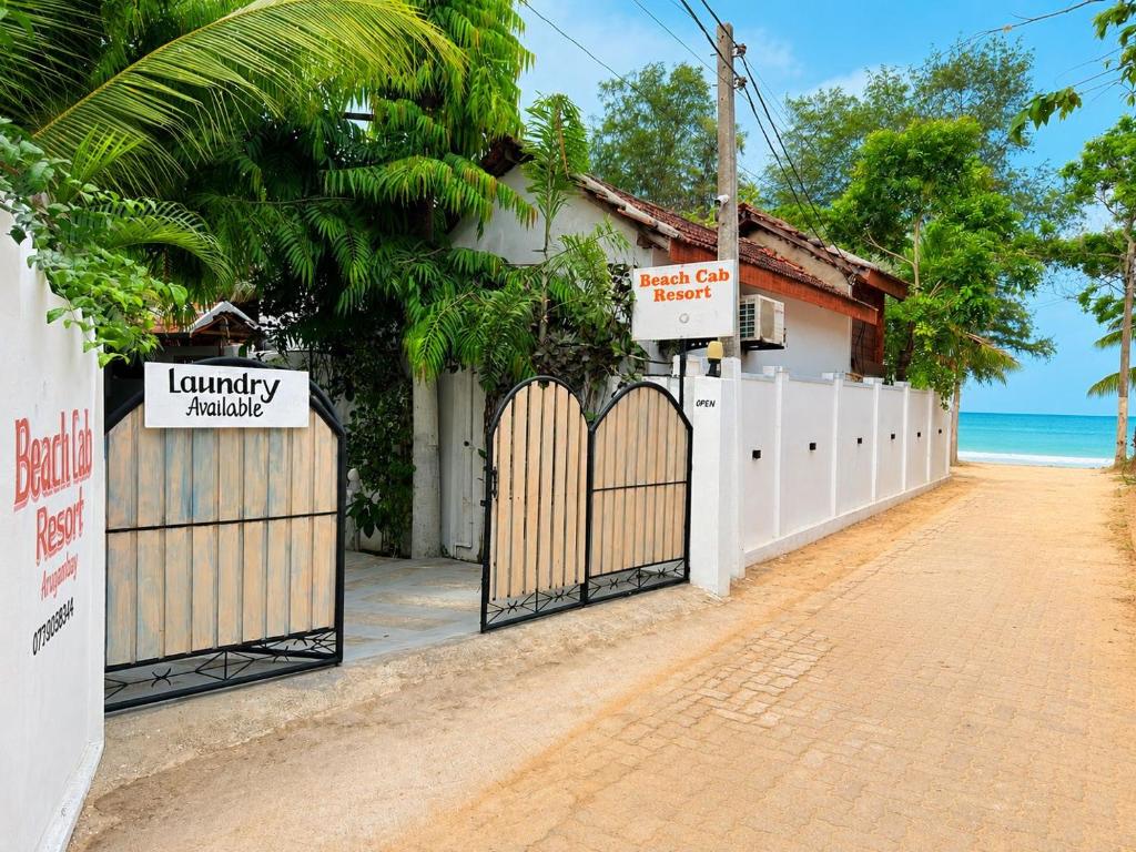 a gate in front of a house with the ocean at Beach Cab Resort in Arugam Bay