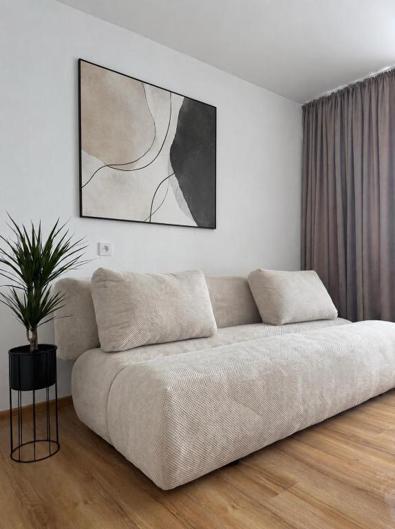 a living room with a couch and a potted plant at Cozy Butukas in Kėdainiai