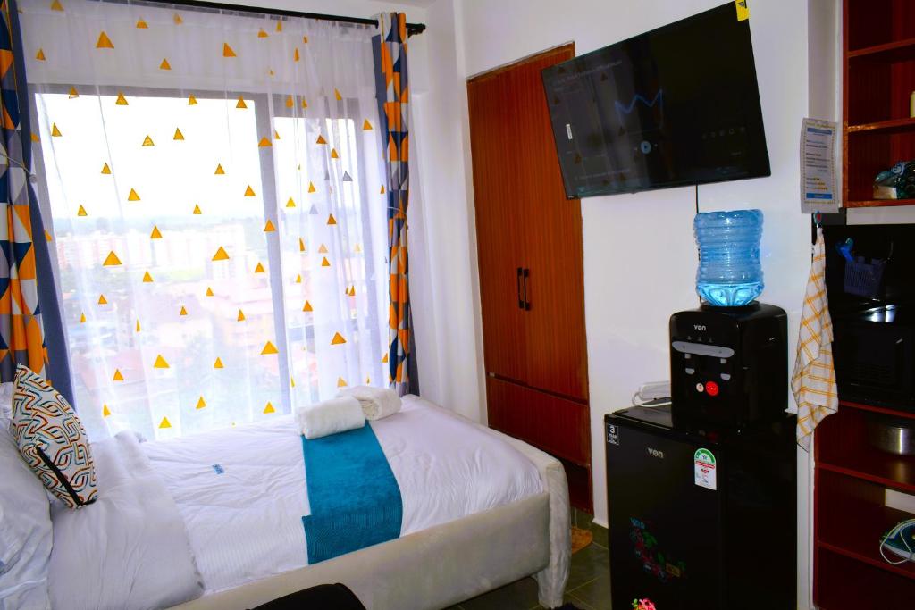 a bedroom with a bed and a window with a curtain at Elegant studio apartment in Kiambu Road Tsavo Apartments in Kiambu