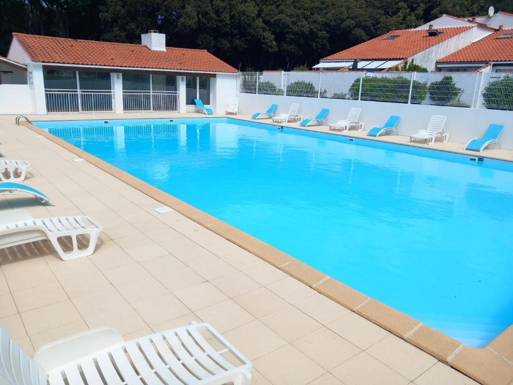 a large swimming pool with lounge chairs in a hotel at La Petite de Cayola in Talmont