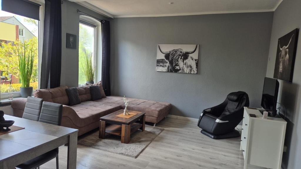 a living room with a couch and a bull on the wall at Stadtnah an der Förde 65 1 in Flensburg