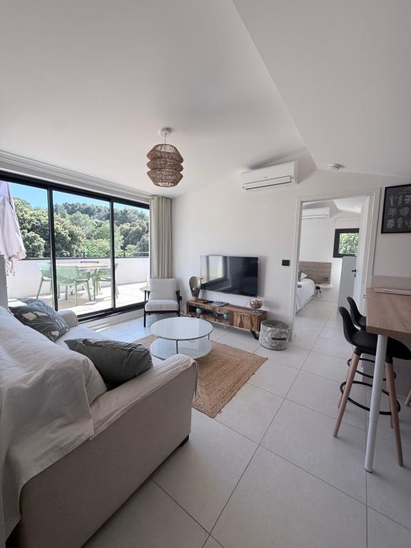 a living room with a couch and a table at Les hauts de Vaison in Vaison-la-Romaine