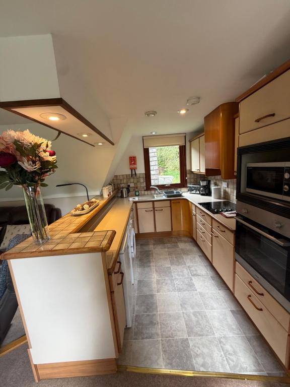 a kitchen with a vase of flowers on a counter at Loch Oich Lodge in Invergarry