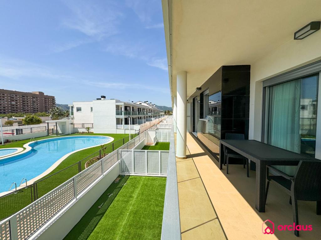 a balcony with a black table and a swimming pool at Sun & Sea in Cabanes