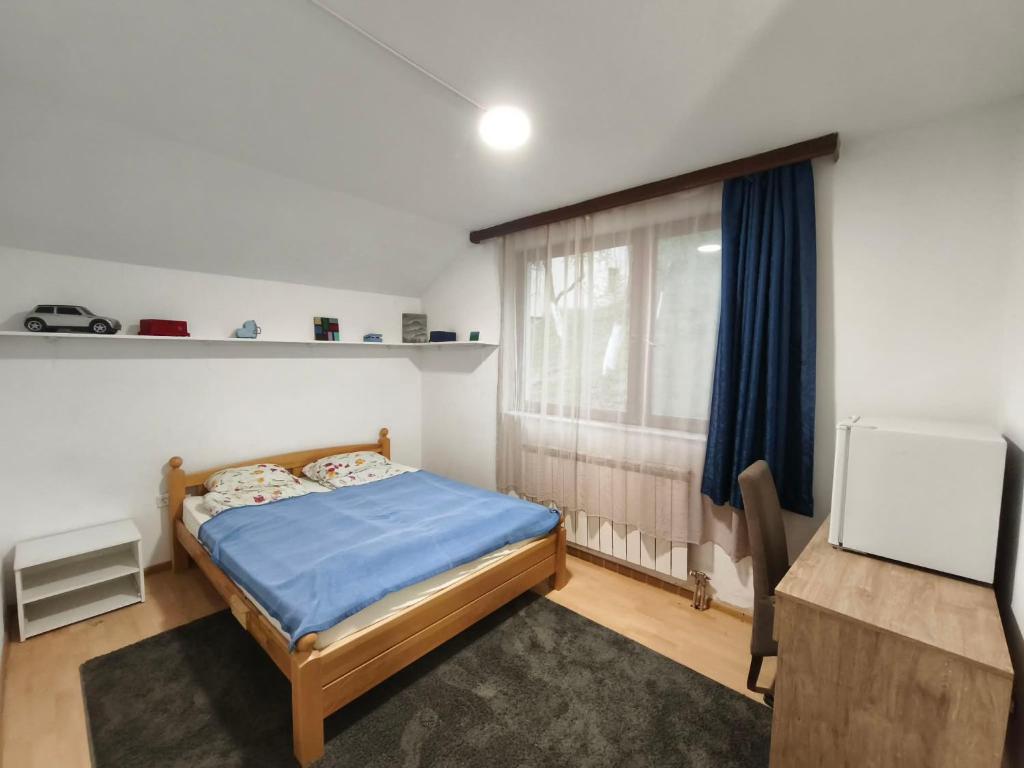 a bedroom with a blue bed and a window at Hideout Guest House in Travnik