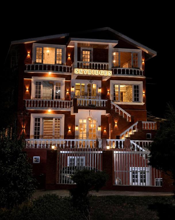 a building with a sign on the front of it at night at SkyRidges in Srinagar