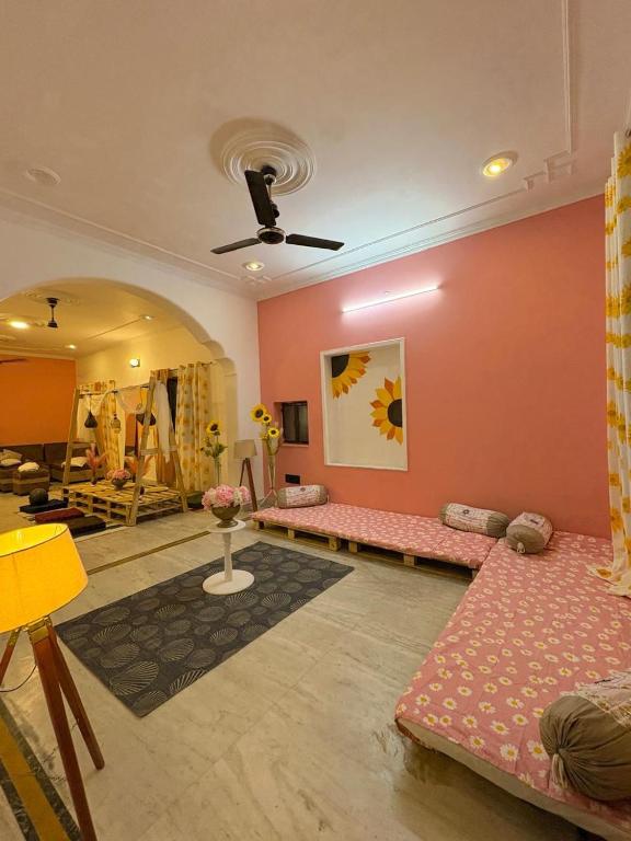 a living room with pink walls and couches at The pink villa in Jaipur