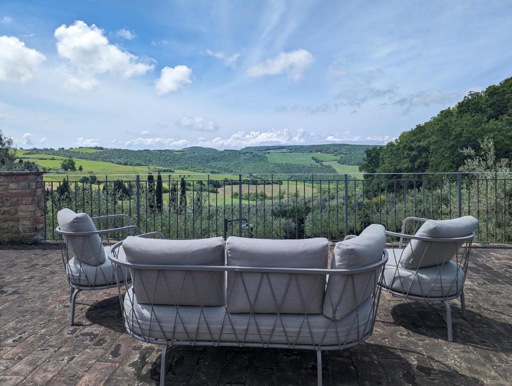 a couch and two chairs on a patio with a view at Sant'Antonio Country Resort in Montepulciano