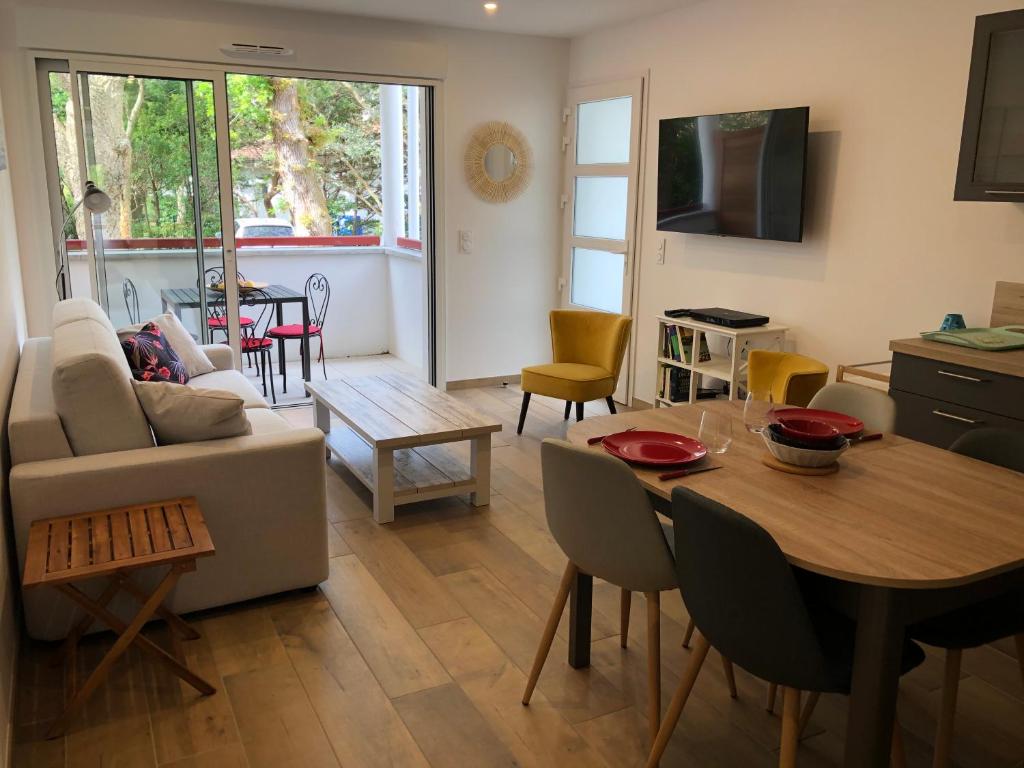 a living room with a couch and a table at Villa Bambous 1 et 2 in Hossegor