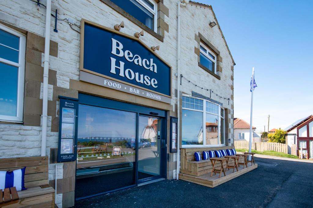 a beach house building with a sign on the side of it at Beach House Hotel in Seahouses