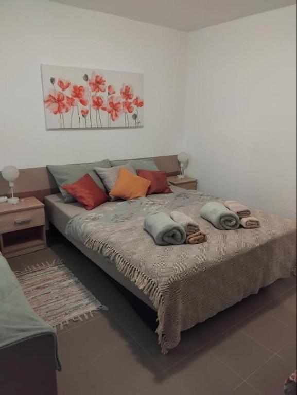 a bed with pillows on it in a room at Apartman "Vuković" in Bizovac