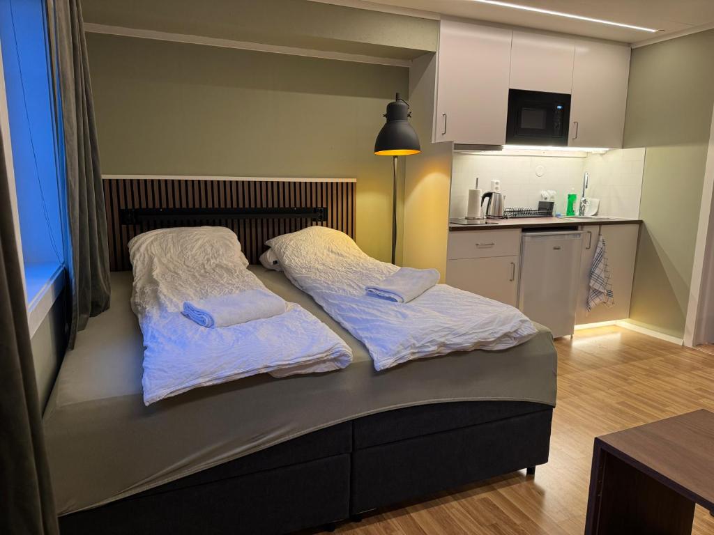 a bed with two pillows on it in a kitchen at Smart mini apartment with kitchen in Åmot