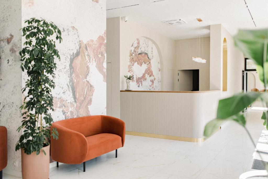 a living room with a orange chair and a mirror at Park Hotel Żywiec in Żywiec