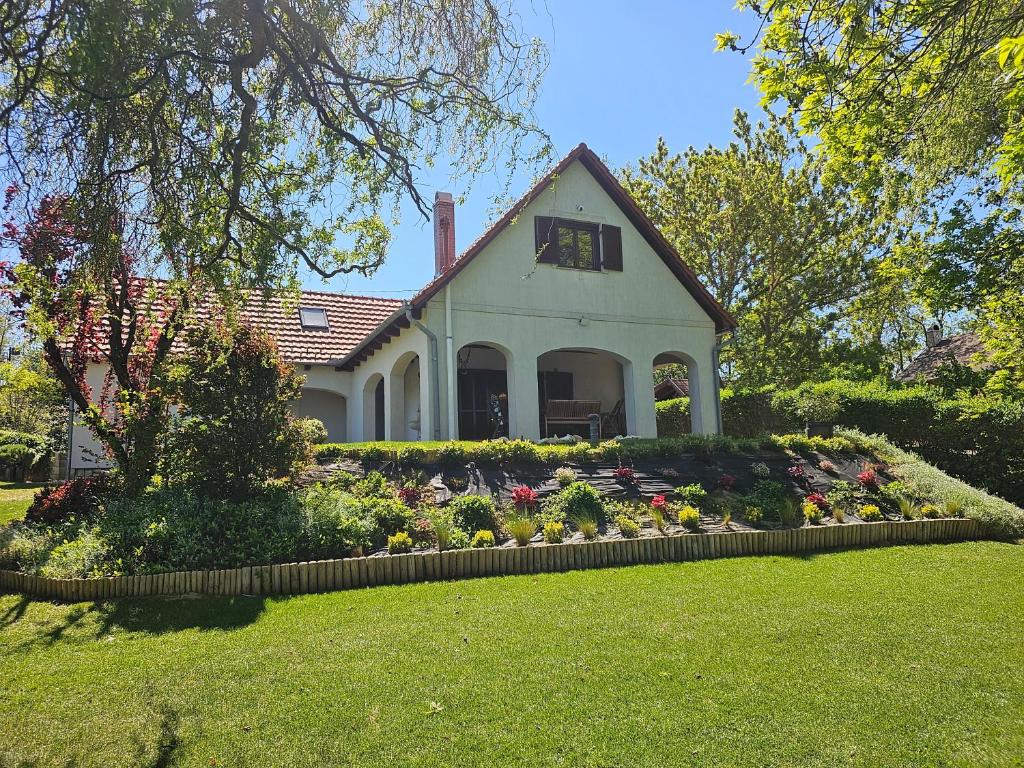 a house with a flower garden in front of it at Waterside Cottage in Nagyrév