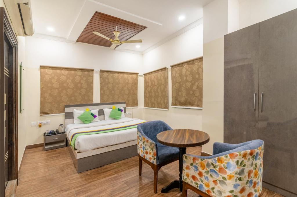 a bedroom with a bed and a table and chairs at Treebo Address Inn, Banjara Hills in Hyderabad