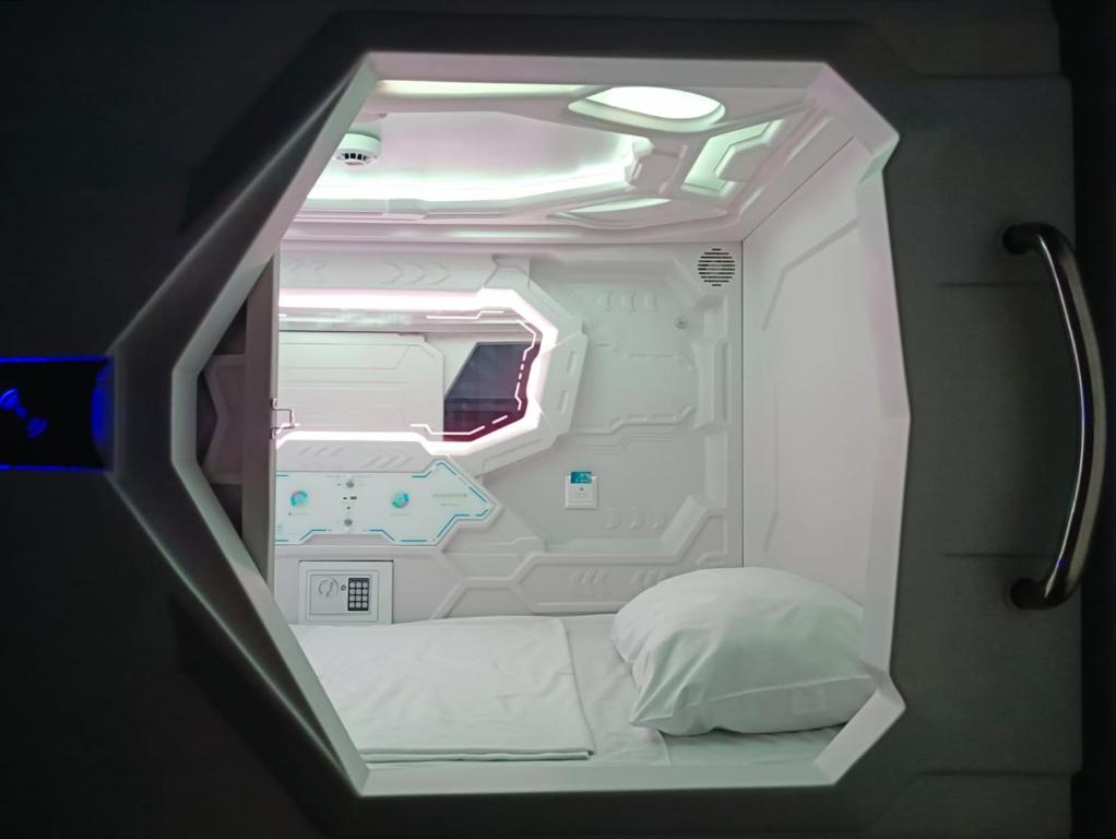 a small white room with a bed in it at Capsule Hotel Happy lounge in Tbilisi City