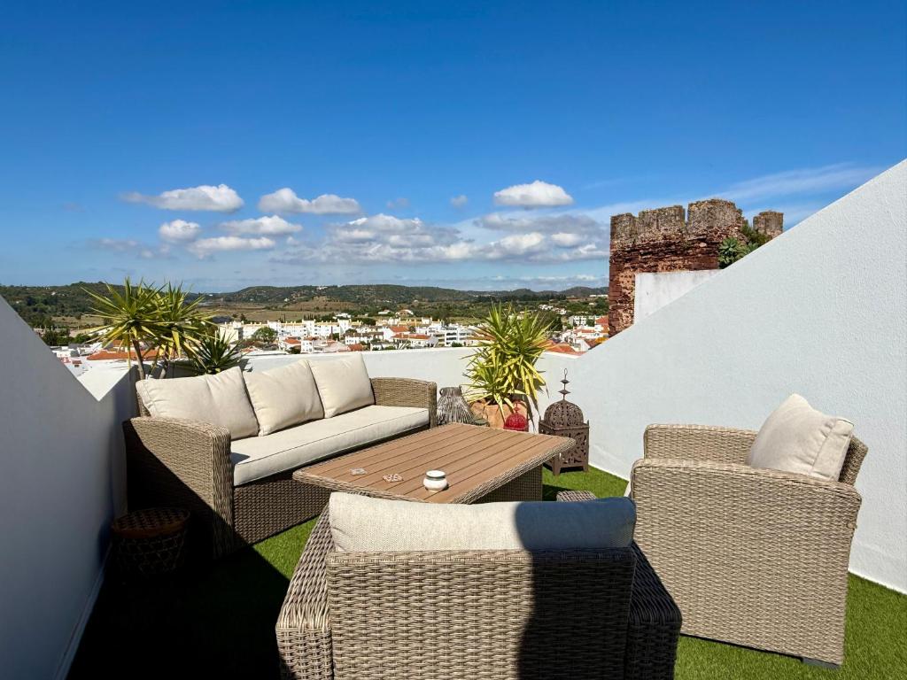 a patio with wicker chairs and a table on a balcony at Casa do Castelo by CORAL in Silves