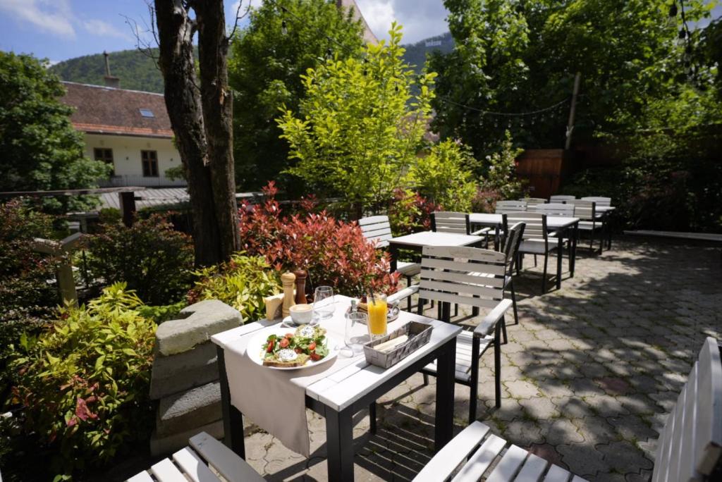 a row of tables and chairs with a plate of food at Barrique Garden - Breakfast & Restaurant - Old Town -Officially classified guesthouse in Braşov